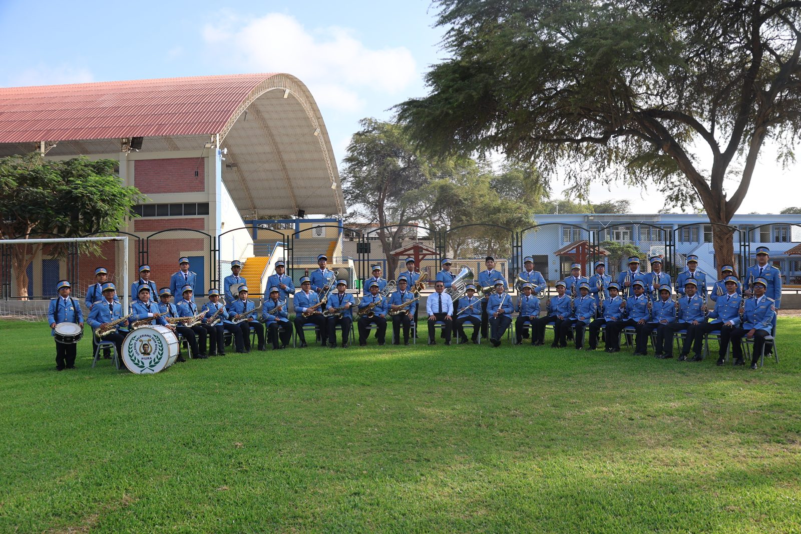 La banda sinfónica del colegio posando junto al patio techado