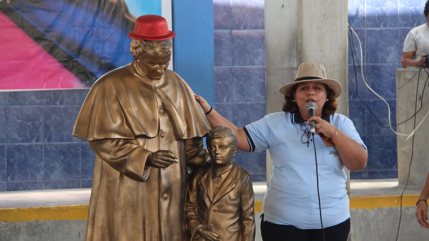 Estatua de Don Bosco con un joven